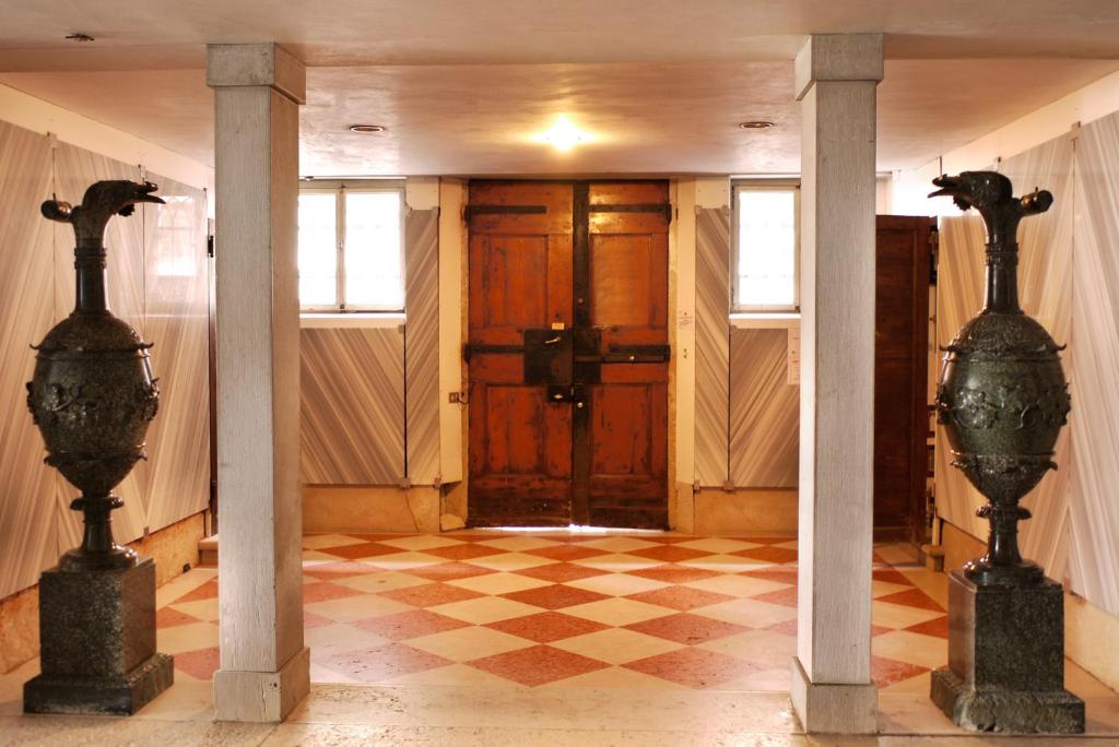 a hallway with two columns and a door with a checkered floor at Casa Dolce in Venice
