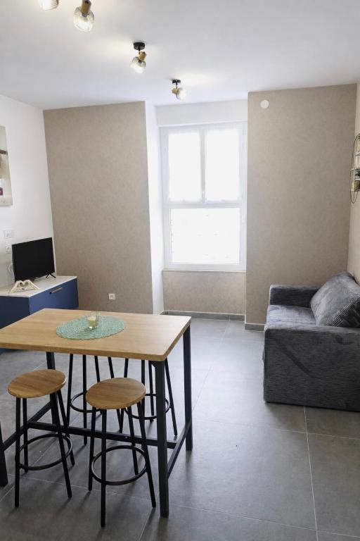 a living room with a table and a couch at Voiron centre - De Tassigny in Voiron