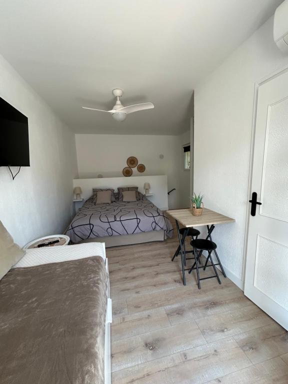 ein Schlafzimmer mit einem Bett und einem Tisch darin in der Unterkunft Elo'Nco in Caderousse