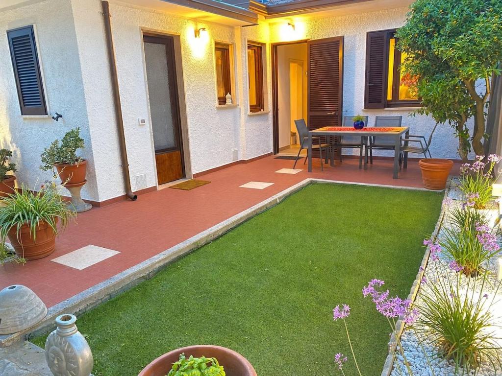 a patio with a table and green grass at La Casina di Perla in Viareggio