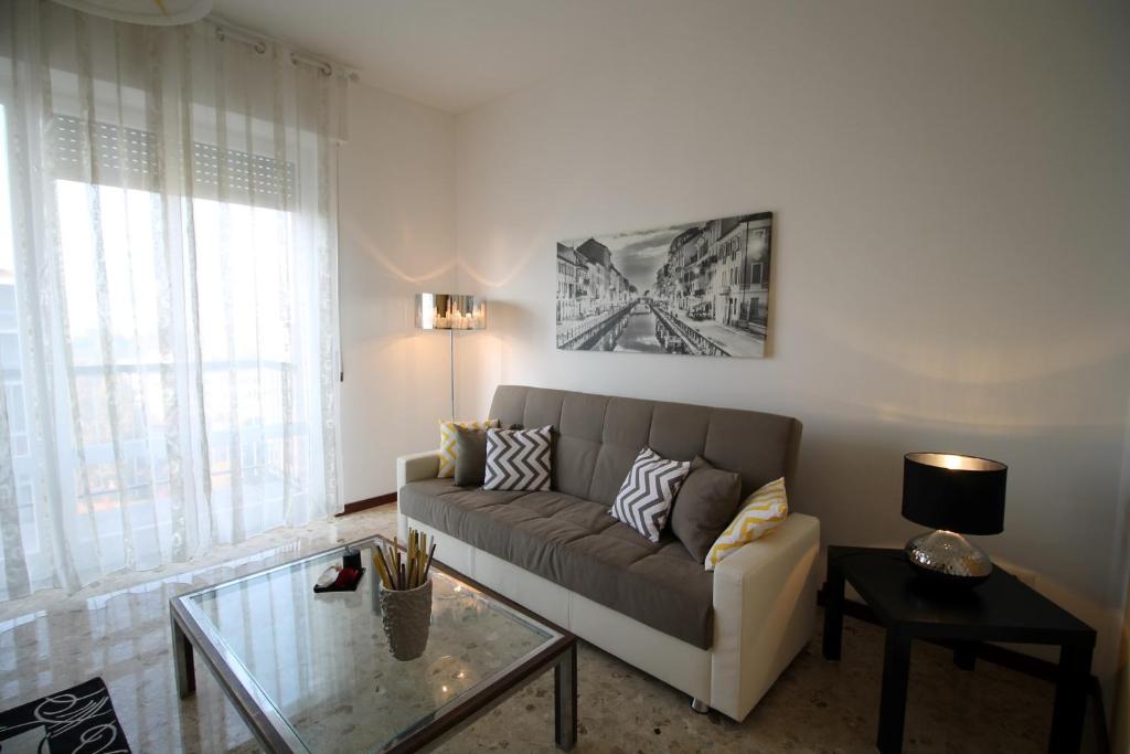 sala de estar con sofá y mesa de cristal en House Navigli, en Milán