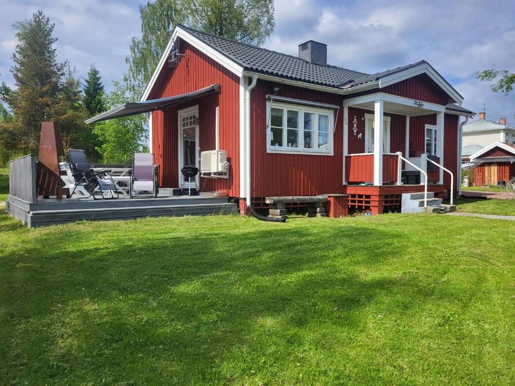 a red house with a large grass yard at Bäcka Holiday Home in Orsa