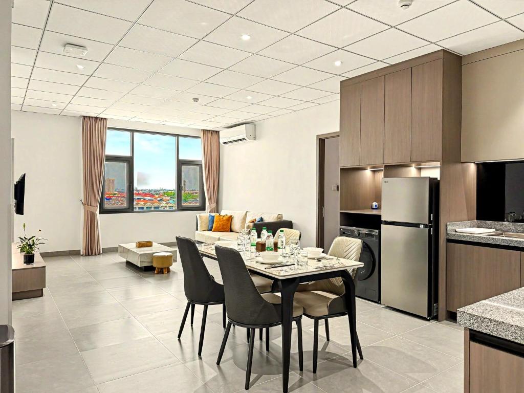 a kitchen and living room with a table and chairs at Modera Residence Grand Phnom Penh, Serviced Apartments in Phnom Penh