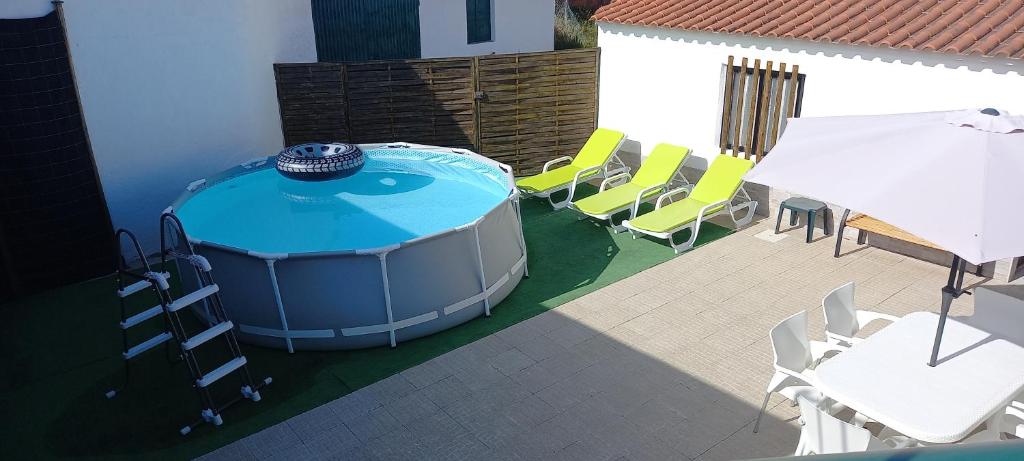 a hot tub on a patio with chairs and a table at Murta's Home in Cadaval