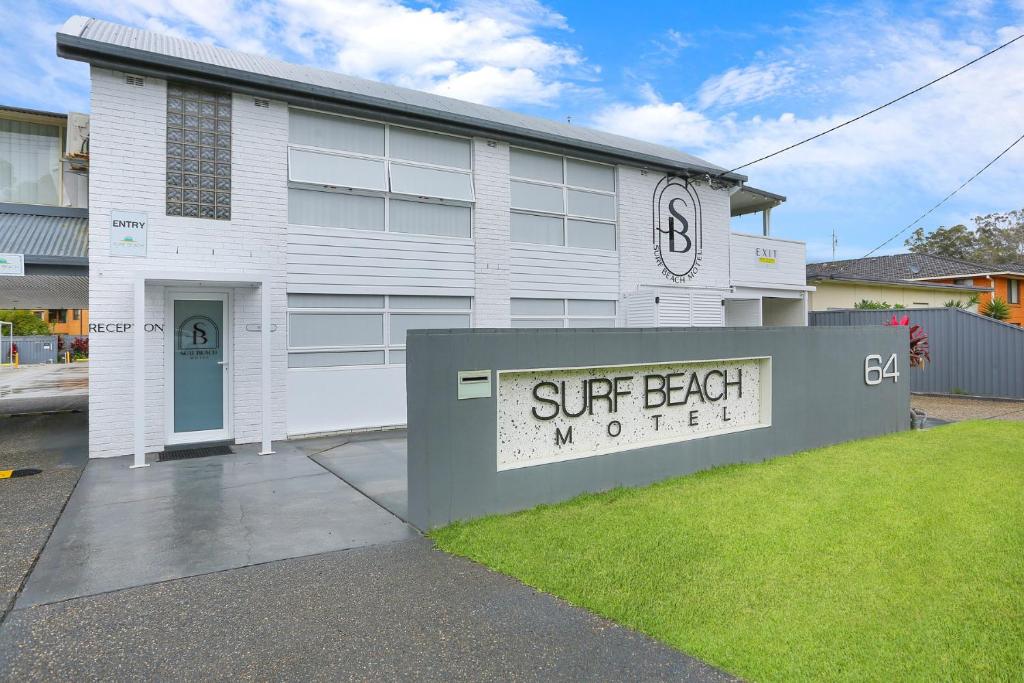 a white building with a sign in front of it at Surf Beach Motel Port in Port Macquarie