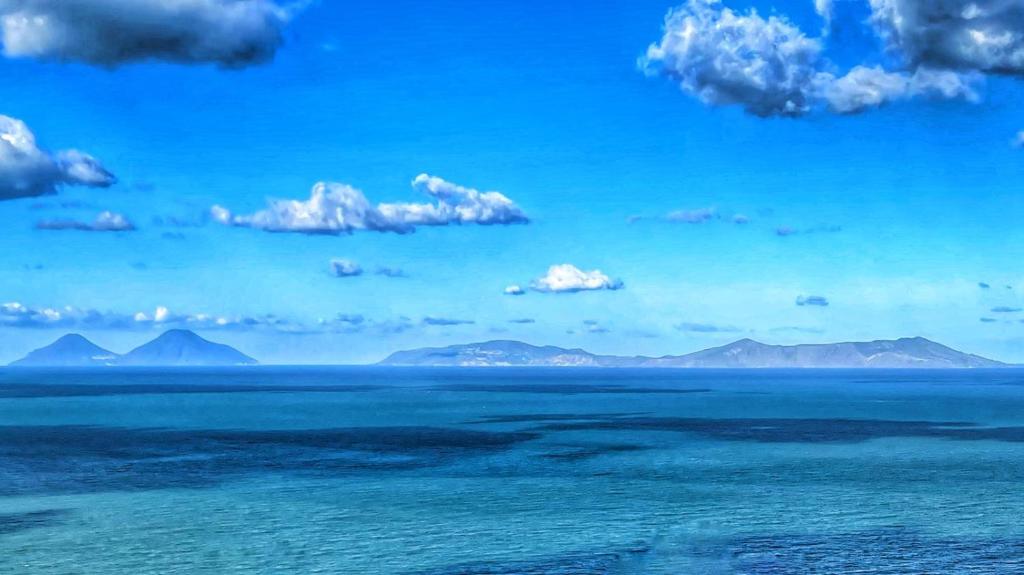 a view of the ocean with mountains in the background at Vista Isole Eolie in Piraino