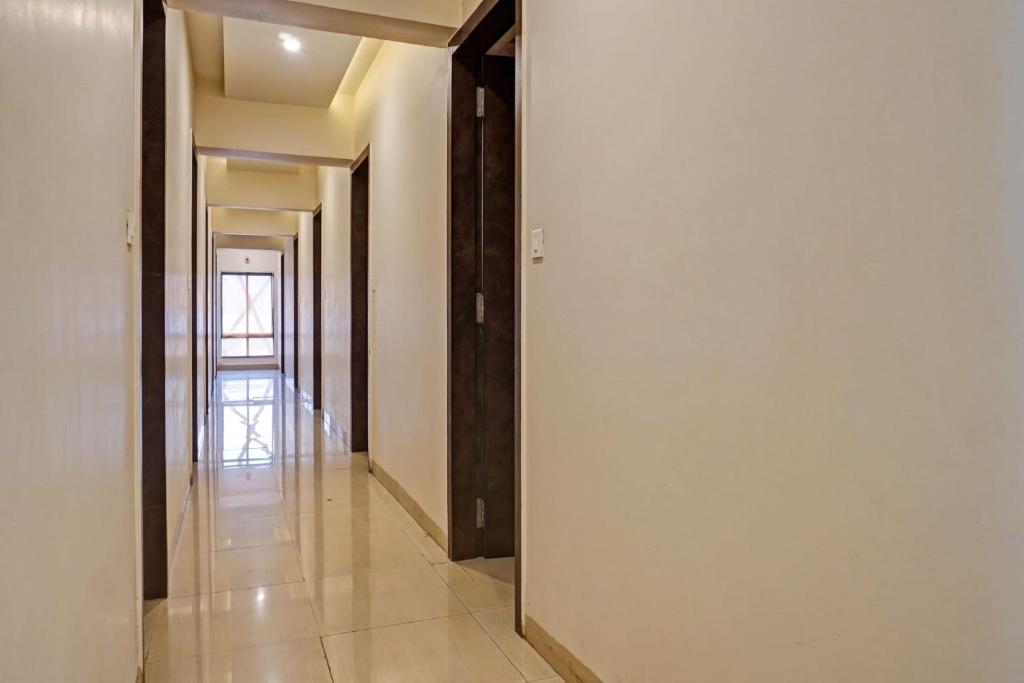 a hallway with white walls and a mirror at Collection O Royce Studios Near Pune Airport in Pune