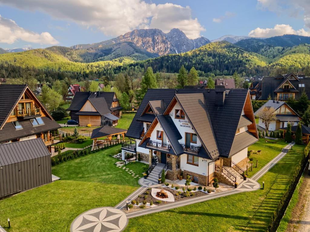 an aerial view of a house with mountains in the background at Rezydencja Skibówki Apartamenty Domki Jacuzzi in Zakopane