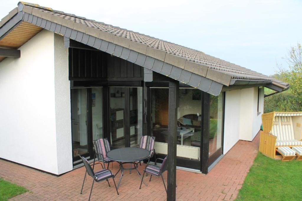 a patio with a table and chairs under an awning at Haus am Meer Eckwarden in Butjadingen