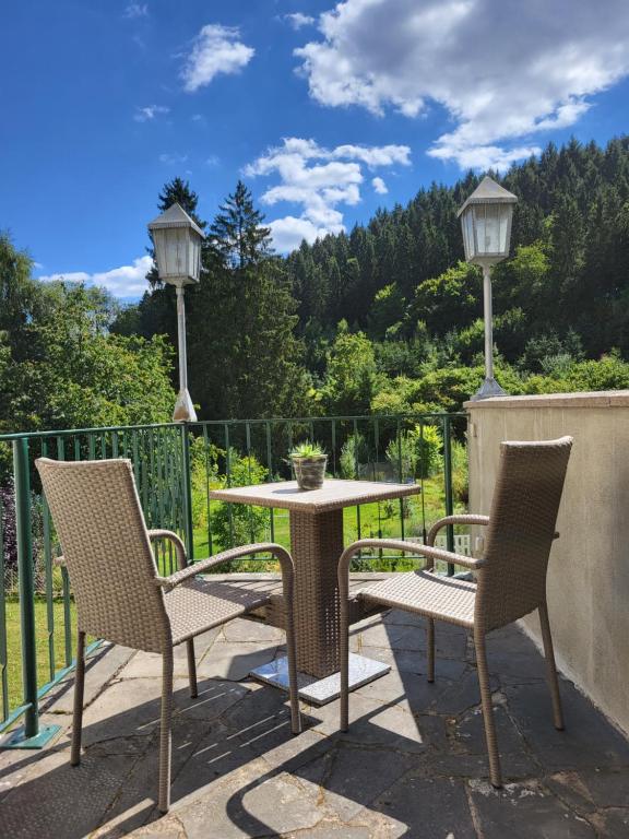 a patio with two chairs and a table and two lights at Ferienwohnung Tutbach in Jünkerath