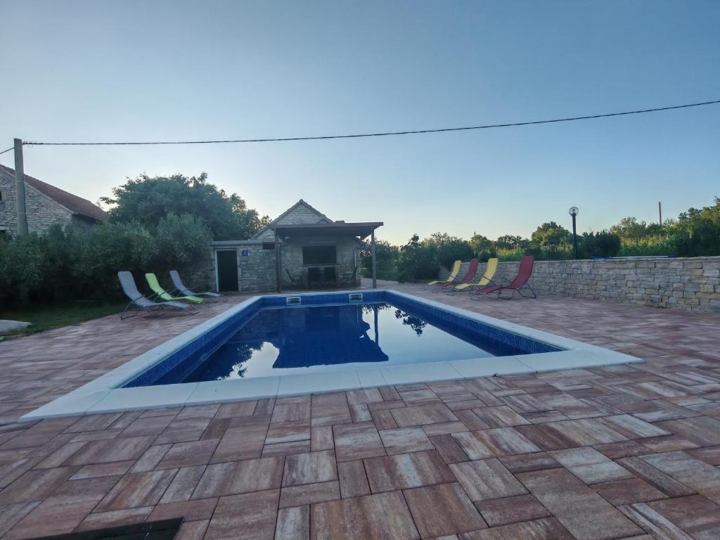a swimming pool in a yard with a patio at Božini dvori in Drniš