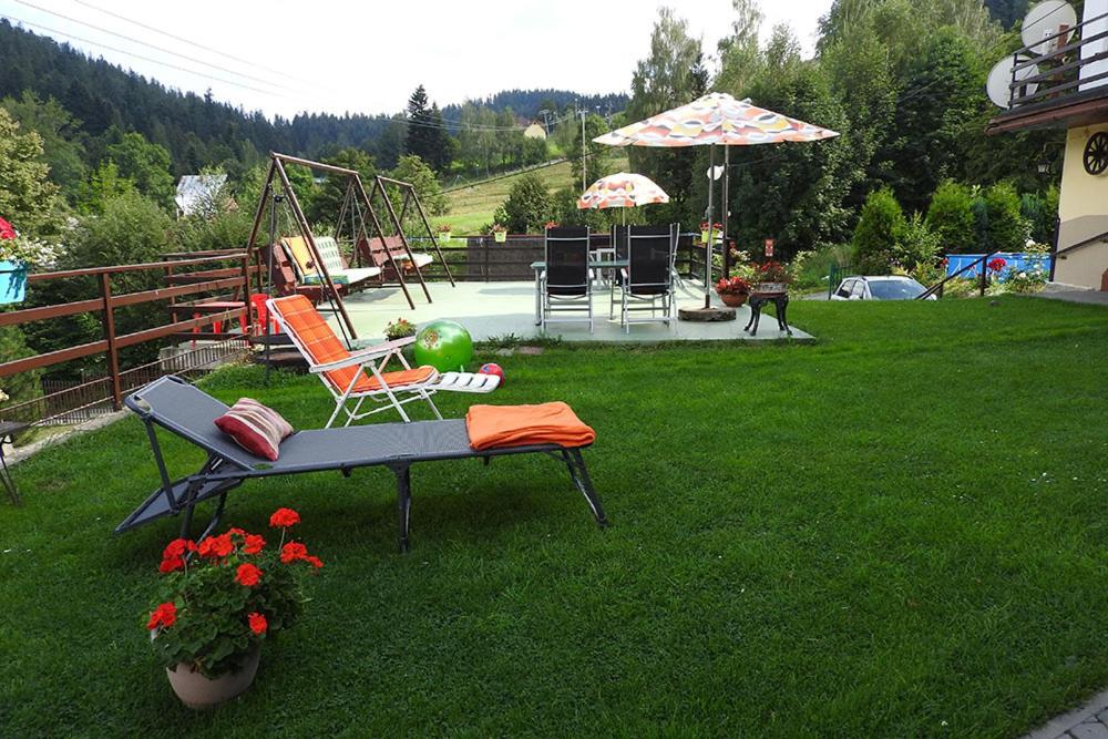 a garden with a bench in the grass at Willa Pod Brzozami in Korbielów