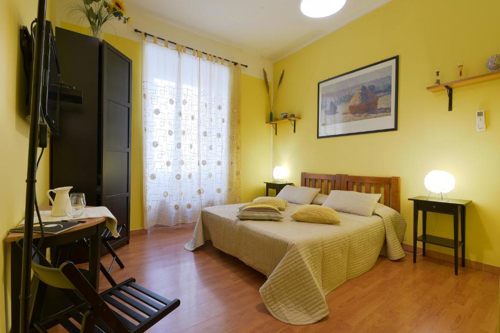 ローマにあるRome Vatican B&Bのベッドルーム1室(黄色い壁とウッドフロアのベッド1台付)