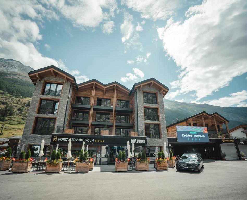 a building with a car parked in front of it at Hotel Porta Cervino - Parking & Dining in Täsch