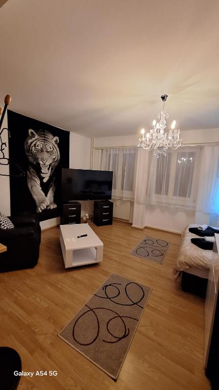a living room with a couch and a chandelier at Spalentor City Apartement in Basel