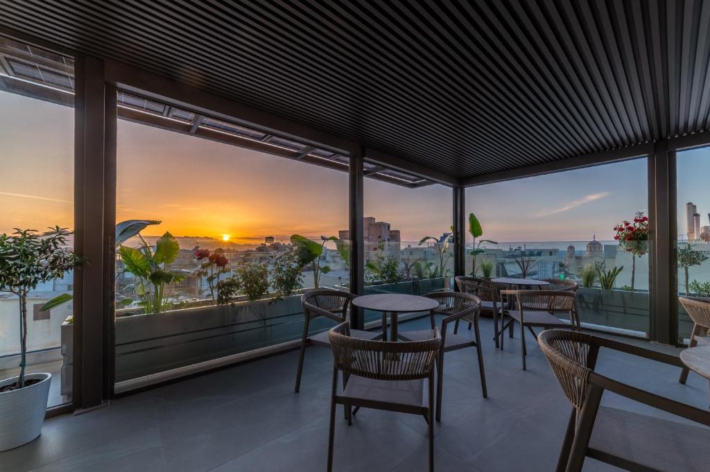 a balcony with tables and chairs and a view of the city at Minotaur's Rest - Luxury Residences with Free Private Parking, near Port & Airport in Heraklio
