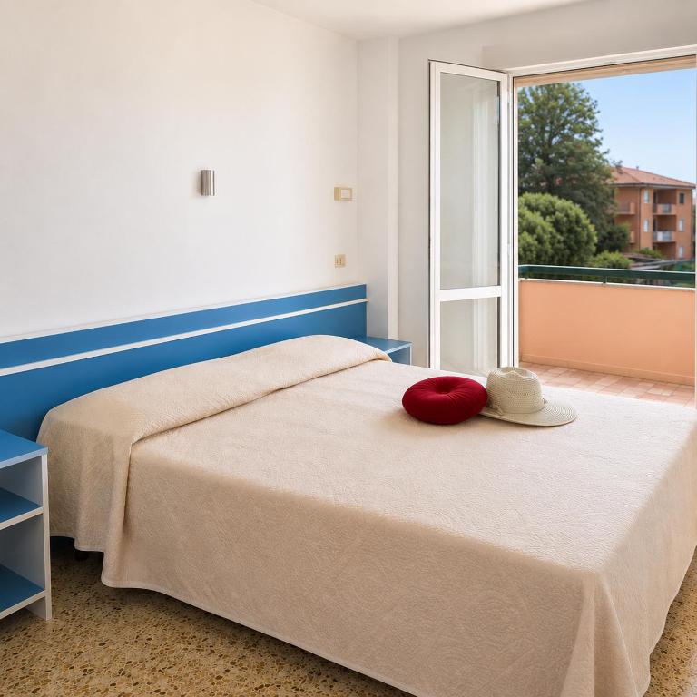 a bedroom with a bed with a hat on it at Adria Residence in Gatteo a Mare