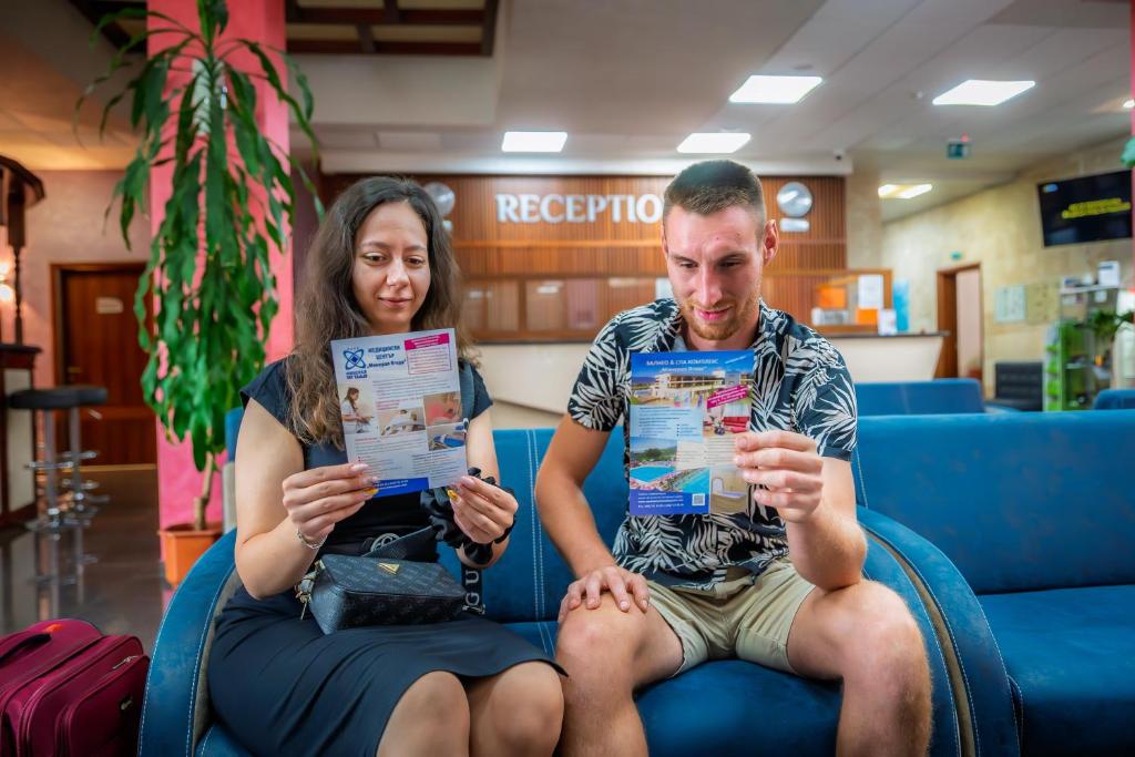 a man and a woman sitting on a couch at Balneo and SPA Complex MINERAL YAGODA in Yagoda