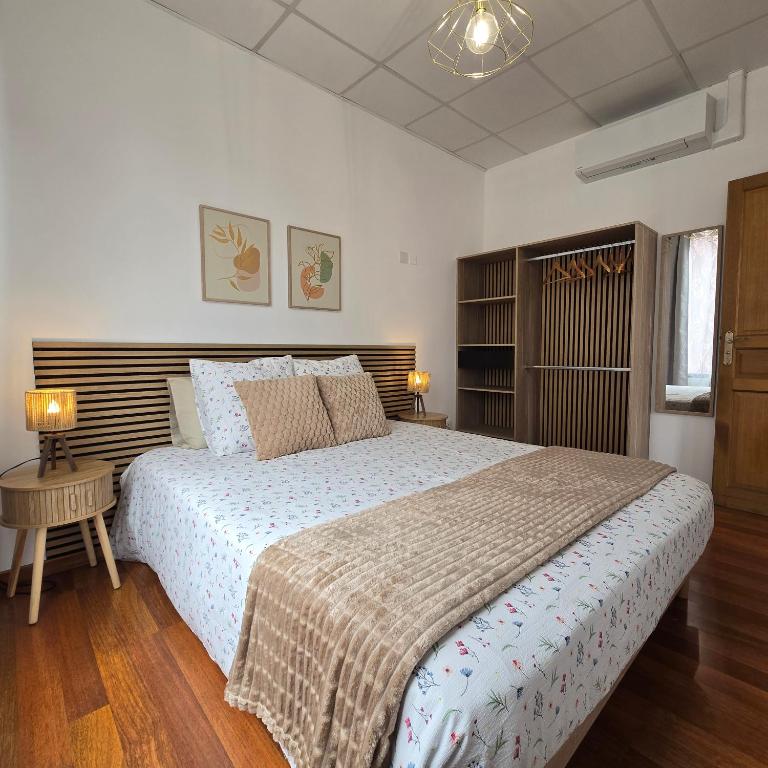 a bedroom with a large bed with a wooden headboard at La Maison Douce Lourdes in Lourdes