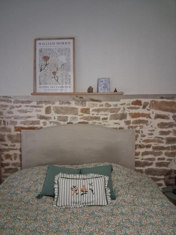 a bedroom with a bed with a brick wall at La grange famille in Tournans