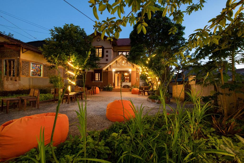 a garden with orange bean bags in front of a house at Tada Moc Chau - Villa & Local Kitchen in Mộc Châu