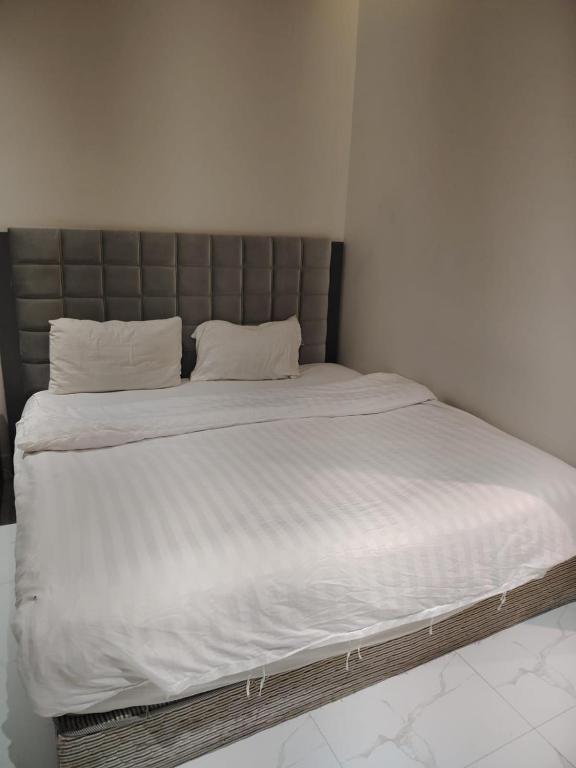a large bed with white sheets and white pillows at استديو داخل بناية حي النرجس in Riyadh
