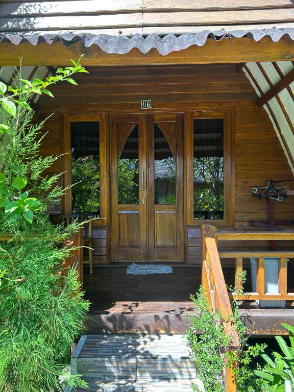 a wooden front door of a wooden house at We'Be Cottages in Gili Meno
