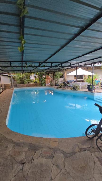 a large blue swimming pool with a roof at Nyali Garden Escape Villa in Mombasa