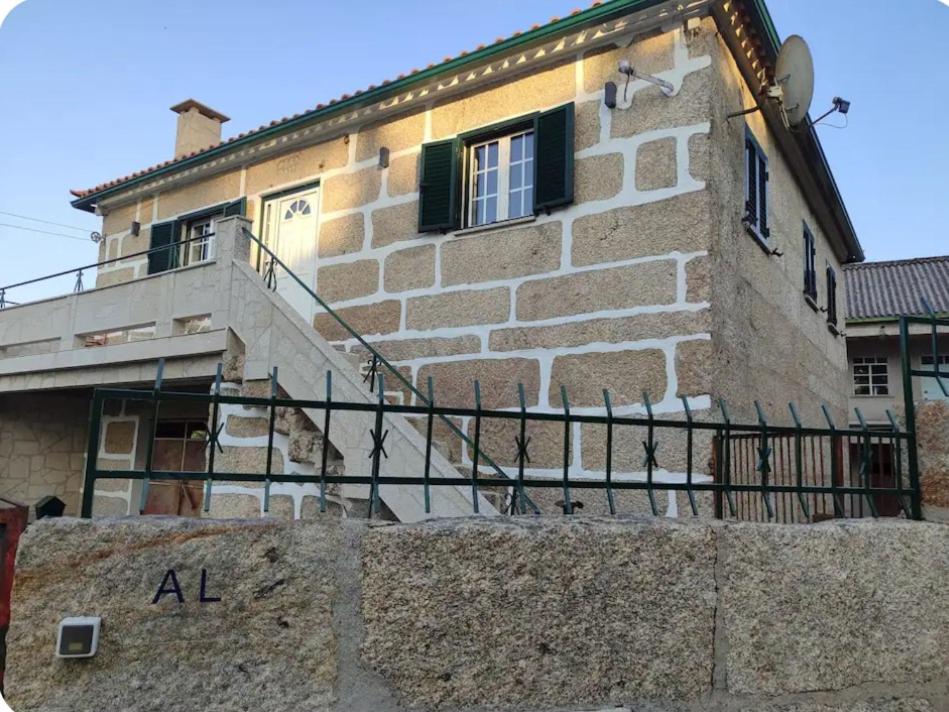 a stone house with a staircase in front of it at Destro village in Lindoso