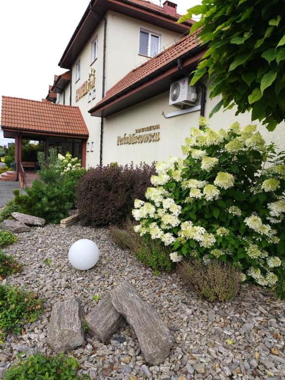 ogród z kwiatami i białą kulą przed budynkiem w obiekcie Hotel TiM w mieście Cekanowo