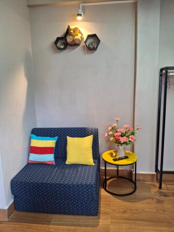 a blue couch and a table with a vase of flowers at GD Homestay in Shillong