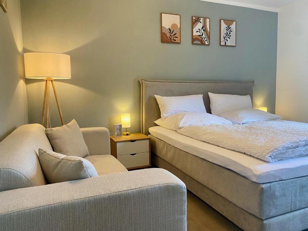 a bedroom with a bed and a chair and a lamp at Weiher Apartment mit Terrasse & Parkplatz in Kulmbach