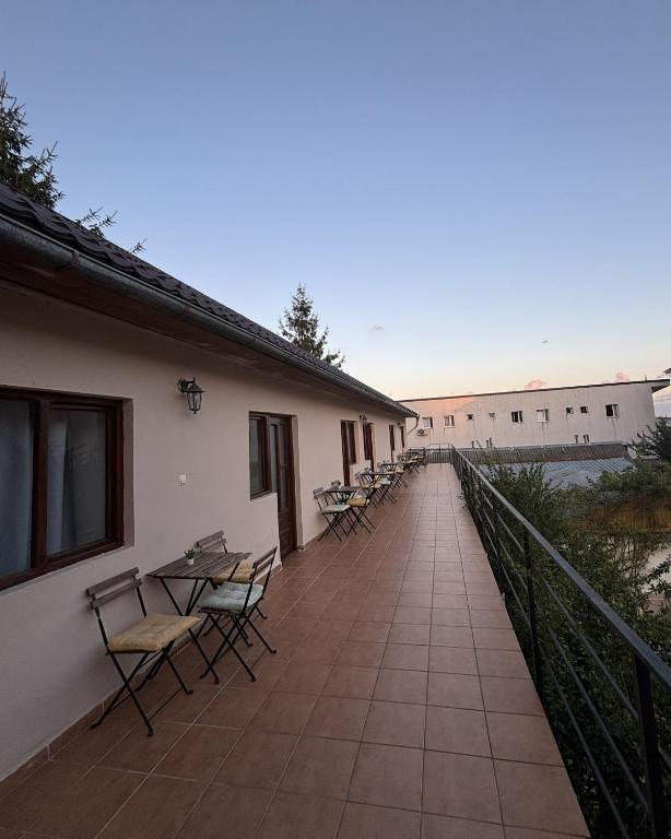 a walkway with chairs and tables on a building at Casa Silvia in Costinesti