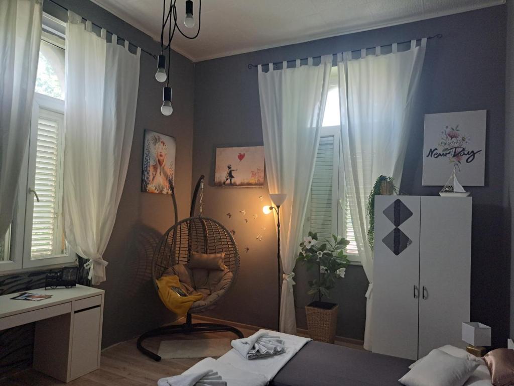 a bedroom with a bed and a desk and windows at Peron 4-City & Station Stay in Rijeka