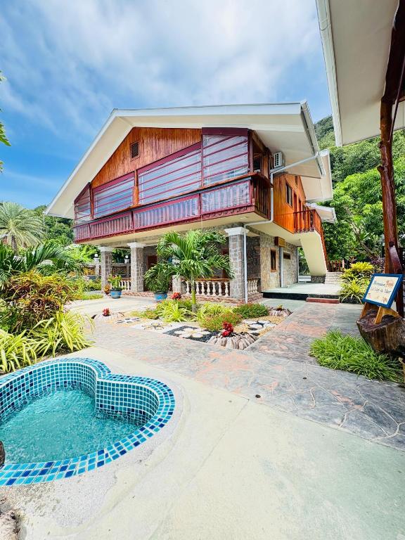 a house with a swimming pool in front of it at La Vue De Mer in La Digue