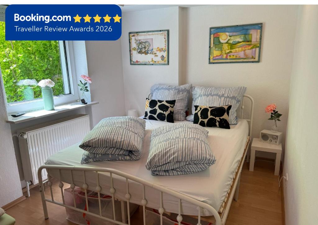 a bed with pillows on it in a bedroom at Gemütliche Ferienwohnung nähe Schloss Benrath & Rhein Düsseldorf Urdenbach in Düsseldorf