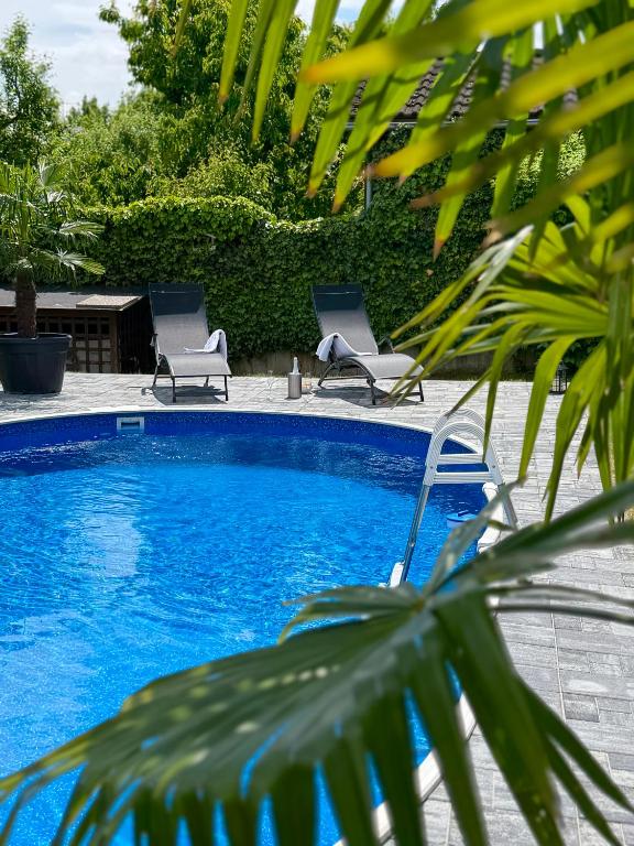 a swimming pool with two chairs and adozen at Komfortný apartmán s bazénom a súkromným parkoviskom - 24h self check-in in Banská Bystrica