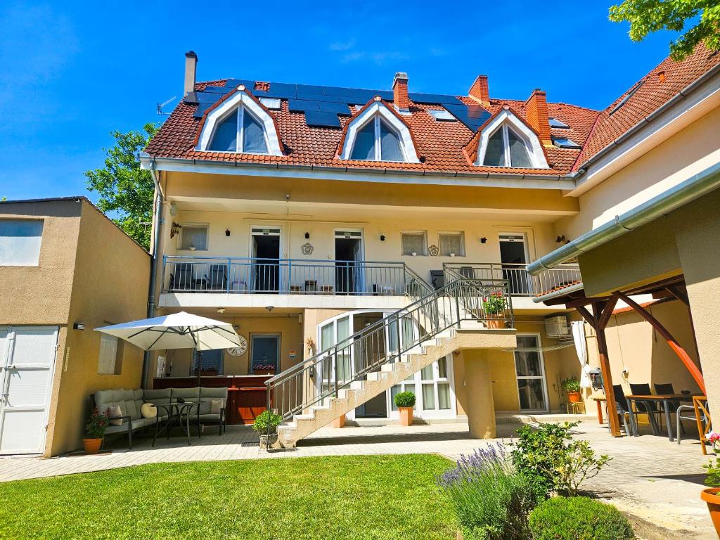 a house with a balcony and a patio at Weinberger Vendégház in Zamárdi