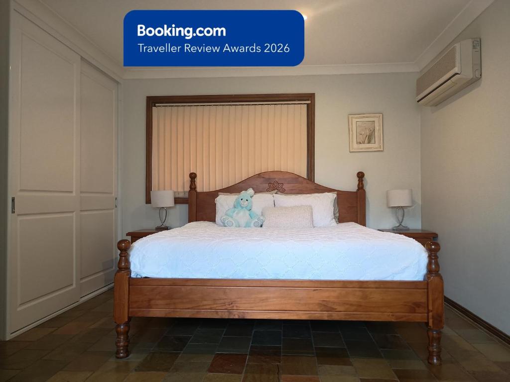 a bedroom with a bed with a teddy bear on it at Baulkham Hills Deluxe King Room with Ensuite, Private Access & Air Con in Baulkham Hills
