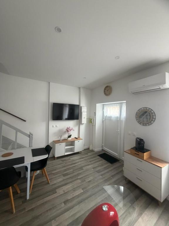a white living room with a piano and a desk at Maison campagne proche A75 in Vergongheon