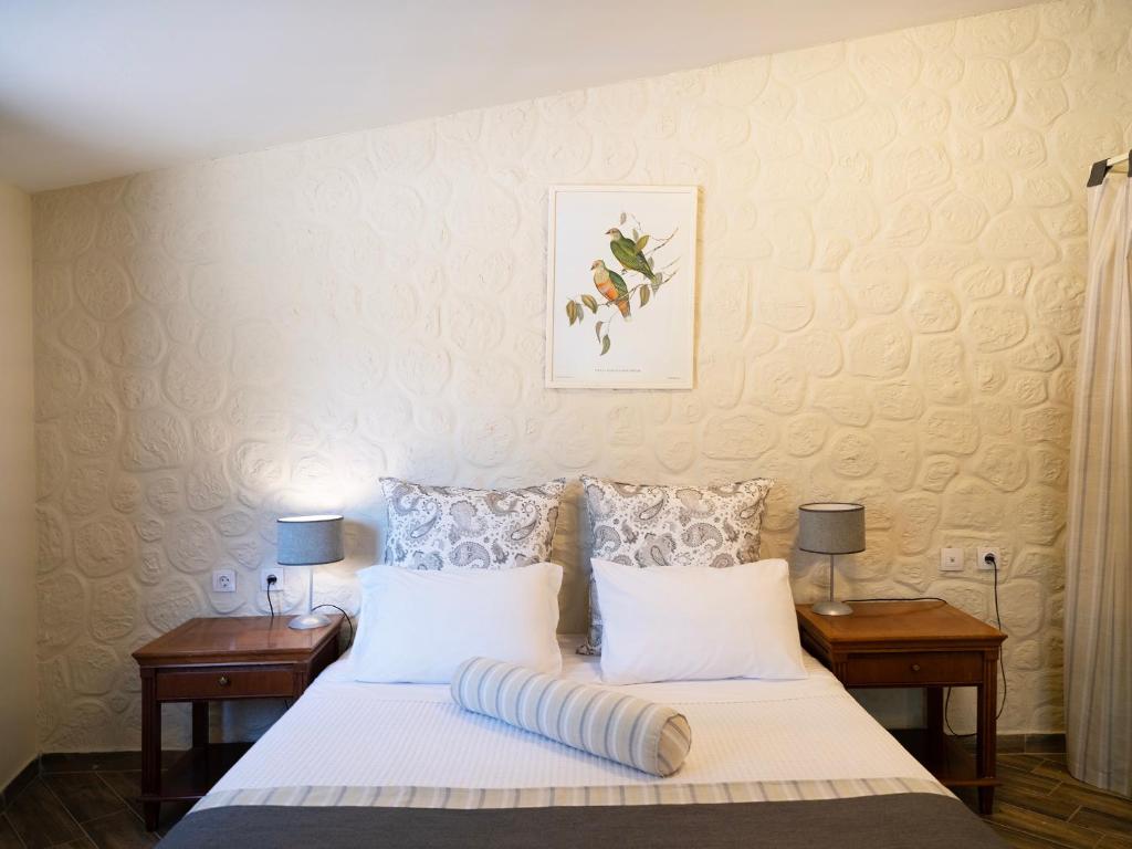 a bedroom with a bed with two night stands and two lamps at Semantron Traditional Village in Diakopto