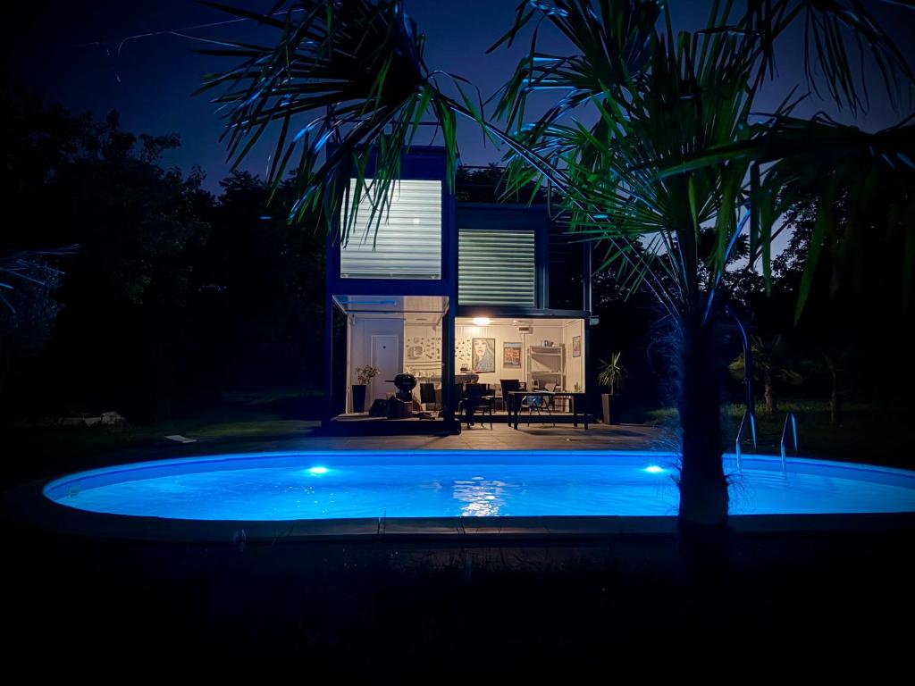 a swimming pool in front of a house at night at Ailleurs in Novi Banovci