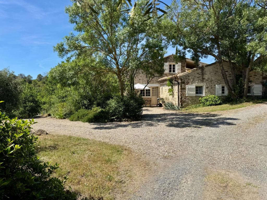 an old stone house with a gravel driveway at Domaine de Villedese in Montlaur