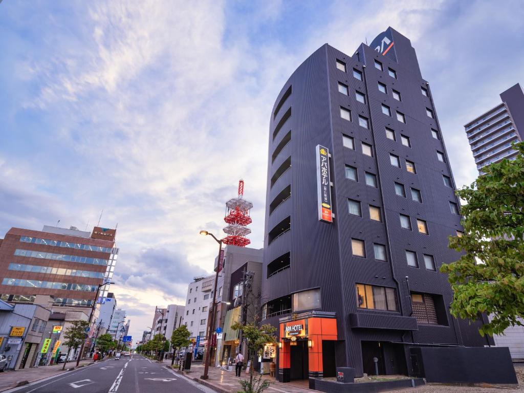a tall building on the side of a city street at APA Hotel Koriyama Ekimae in Koriyama