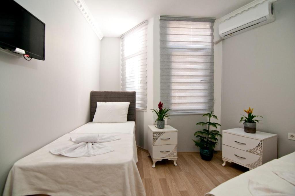 a bedroom with two beds and a tv and a window at Terrace Hotel in Istanbul
