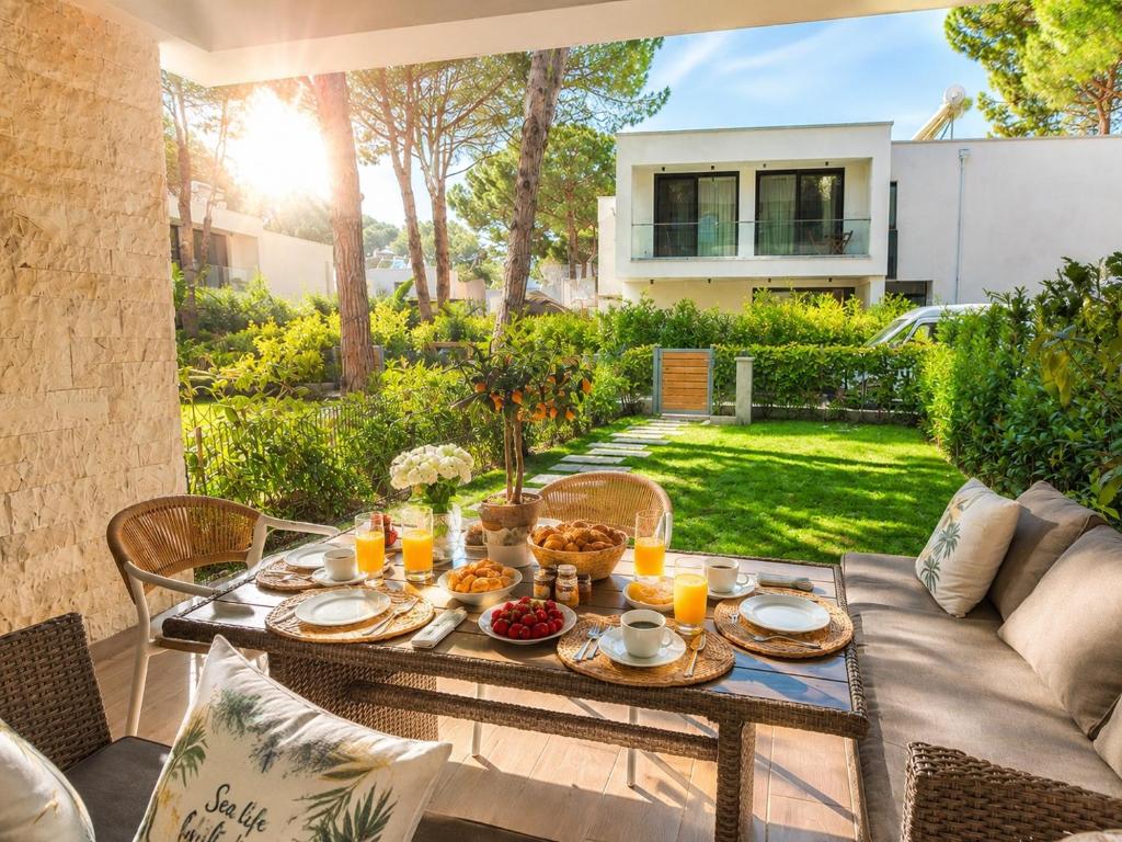 a table with food and drinks on a patio at San Pietro Premium Meliá Garden Apartment in Lalzit Bay