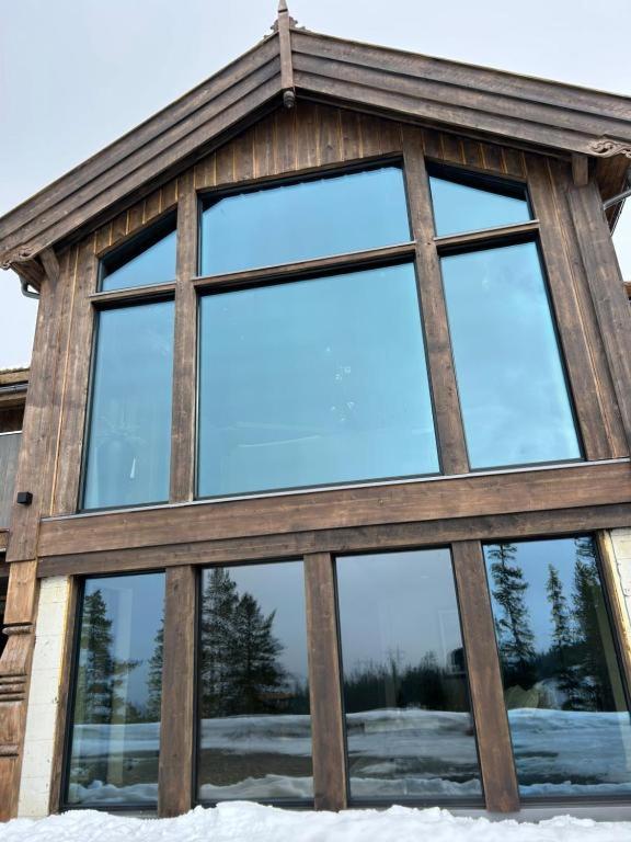 a wooden building with windows in the snow at Stor hytte på Gaustablikk in Gaustablikk