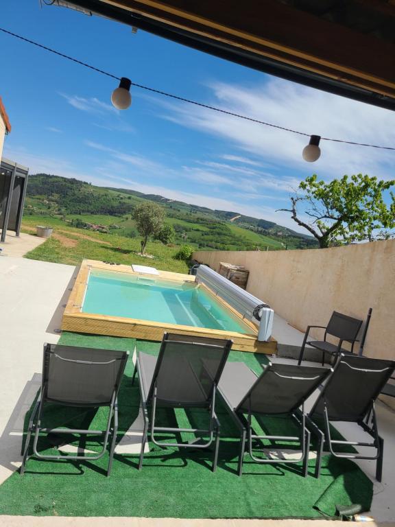 a group of chairs and a table and a swimming pool at Le QG chez Flo et David in Saint-Julien-Molin-Molette