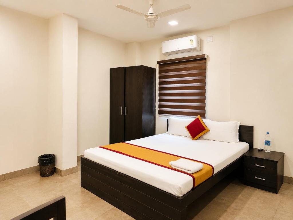 a bedroom with a bed with a brown cabinet at Raaha Residency in Kozhikode