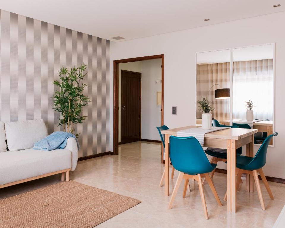 a dining room and living room with a table and chairs at Lourença Stays - Vila Beach Apartment 1 in Vila do Conde